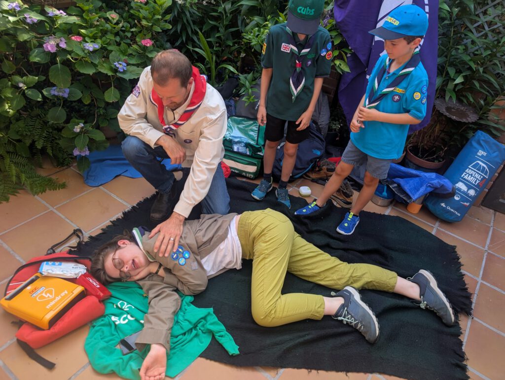 Niños de St. George School aprendiendo a usar un desfibrilador DESA y realizando maniobras de RCP durante el campamento cardioprotegido First Scout.