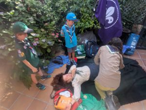 Niños de St. George School aprendiendo a usar un desfibrilador DESA y realizando maniobras de RCP durante el campamento cardioprotegido First Scout.