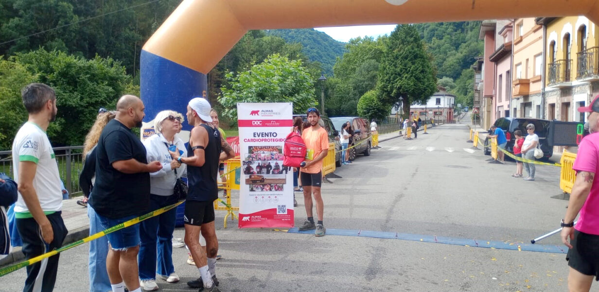 Manuel Merillas, campeón mundial de trail running, posando junto a un desfibrilador de Proyecto + Vida en la Travesía de Belmonte 2025